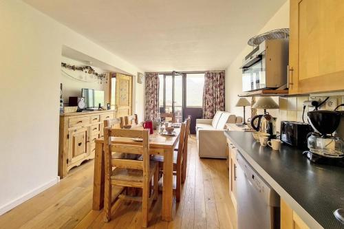 une cuisine avec une table et des chaises dans une pièce dans l'établissement Résidence Burons - Appartement · Balcon sud MAE-9684, aux Menuires