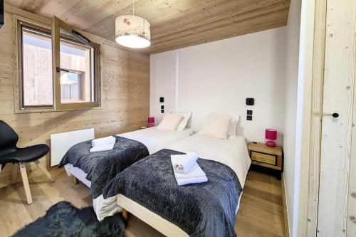 a bedroom with two beds and a chair at Résidence Le Bettex - Chalet YDILIA MAE-9694 in Praranger