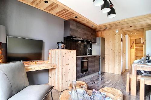 een woonkamer met een bank en een tv en een keuken bij Résidence Valmonts A - Appartement duplex rénové · Départ ski aux pieds · Balcon MAE-9904 in Les Bruyères