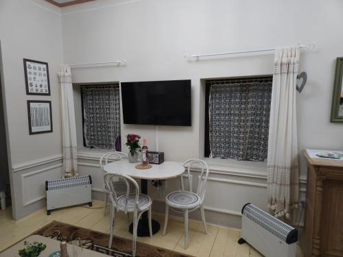 a dining room with a table and chairs and a tv at Apartmán Marína in Banská Štiavnica