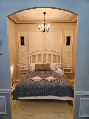 a bedroom with a large bed with a chandelier at Apartmán Marína in Banská Štiavnica