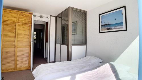 une chambre avec un lit et une porte coulissante en verre dans l'établissement Résidence Caron - Appartement duplex lumineux · Départ et retour skis aux pieds · Balcon MAE-0004, aux Menuires