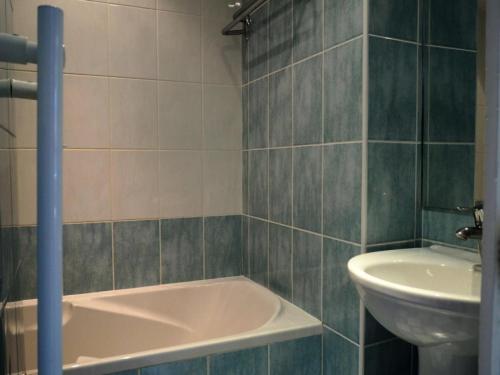 une salle de bain avec une baignoire et un lavabo dans l'établissement Résidence Caron - Appartement duplex lumineux · Départ et retour skis aux pieds · Balcon MAE-0004, aux Menuires
