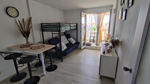 - un salon avec une table et des lits superposés dans l'établissement Studio avec vue sublime sur l'étang et les montagnes catalanes, au Barcarès