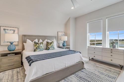 a white bedroom with a large bed and two windows at Fridays Comin 132 BAR in Mustang Beach