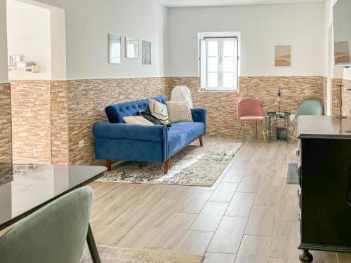 a living room with a blue couch and a table at Casinha da Serra in Vilar