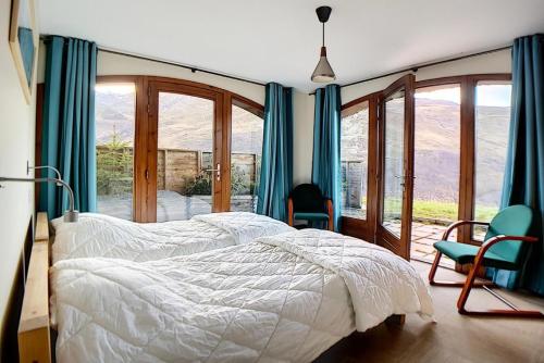 Résidence Les Cristaux - Appartement rénové · Proche des pistes · Balcon · WIFI · Hammam · Sauna MAE-0074 في Levassaix: غرفة نوم بسرير وكراسي ونوافذ