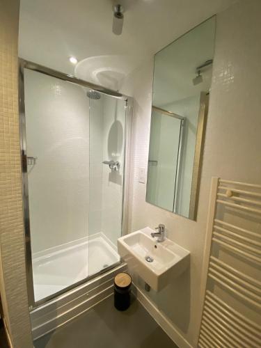 a white bathroom with a shower and a sink at Rotunda - New Street, City Centre, Birmingham in Birmingham