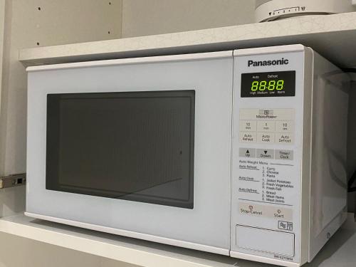 a white microwave oven sitting on a shelf at Rotunda - New Street, City Centre, Birmingham in Birmingham