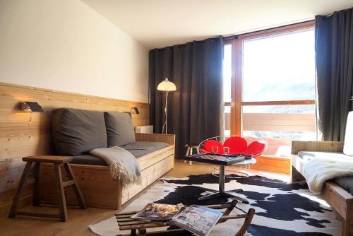 un salon avec un canapé et une grande fenêtre dans l'établissement Résidence Grande Masse - DUPLEX 4 pièces Rénové 8 personnes MAE-0094, aux Menuires