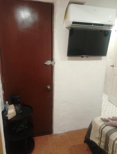 a door to a room with a bed and a television at Casa Nance Alojamientos COBA Mercado 28 Smart TV y ADO Centro in Cancún