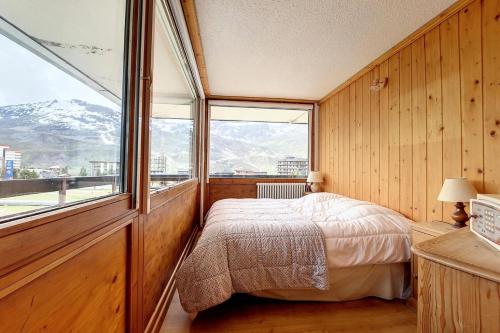 une chambre avec un lit et une grande fenêtre dans l'établissement Résidence Aravis - Appartement spacieux · Skis aux pieds · Balcon vue station MAE-0244, aux Menuires