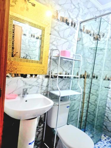 a bathroom with a sink and a shower with a mirror at Apprt Ennakhil 2 in El Jadida