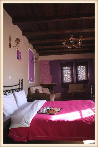 a bedroom with a large bed with a red blanket at Voreas Hotel in Kato Loutraki