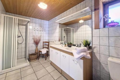 ein weißes Badezimmer mit Waschbecken und Dusche in der Unterkunft Résidence Les Granges - Chalet spacieux · Centre village des Granges · Sauna MAE-0184 in Saint-Marcel
