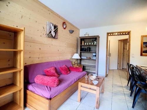 un salon avec un canapé violet et une table dans l'établissement Résidence Balcons D'olympie - 2 Pièces pour 6 Personnes 344, aux Menuires
