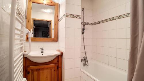 une salle de bain avec un lavabo, un miroir et une baignoire dans l'établissement Résidence Sapiniere - Appartement spacieux · Départ ski aux pieds · Terrasse spacieuse MAE-0414, aux Menuires