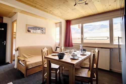 - une salle à manger avec une table, un lit et une fenêtre dans l'établissement Résidence Les Lauzes - Appartement rénové · Départ et retour ski aux pieds MAE-0454, aux Menuires