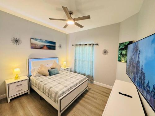 a bedroom with a bed and a flat screen tv at Luxurious & Epic Condo in heart of Orlando in Orlando