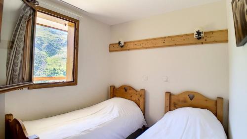 zwei Betten in einem Zimmer mit Fenster in der Unterkunft Résidence Les Cristaux - Appartement spacieux & rénové · Proche des pistes · Balcon · Sauna · Hammam · WIFI MAE-0524 in Levassaix