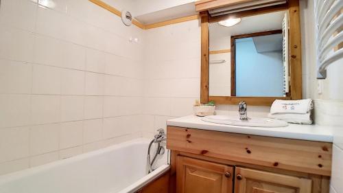 ein Badezimmer mit Waschbecken, Badewanne und Spiegel in der Unterkunft Résidence Les Cristaux - Appartement spacieux & rénové · Proche des pistes · Balcon · Sauna · Hammam · WIFI MAE-0524 in Levassaix