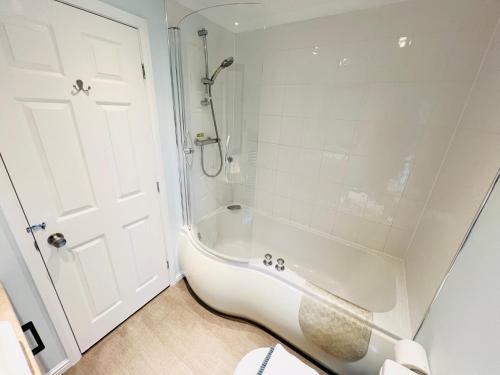 a white bathroom with a shower and a tub at 3 Bedroom Lodge SG2, Lower Hyde, Isle of Wight in Shanklin