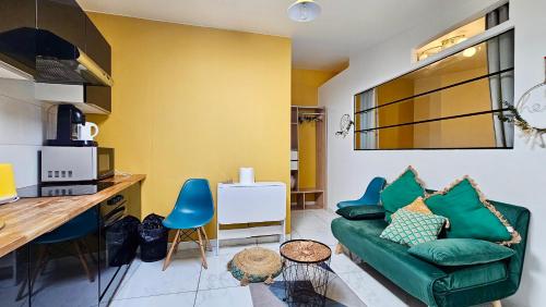 un salon avec un canapé vert et une cuisine dans l'établissement Magnifique T2 proche Paris et Stade de France, à Stains