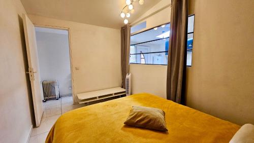 スタンにあるMagnifique T2 proche Paris et Stade de Franceのベッドルーム1室(黄色いベッド1台、窓付)