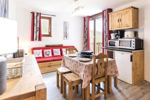 une cuisine et un salon avec une table et des chaises dans l'établissement Résidence Ski Soleil - Appartement spacieux · Départ ski aux pieds · Balcon vue sur les pistes MAE-0544, aux Menuires