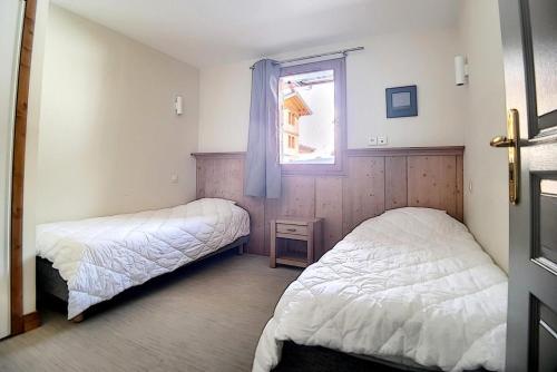 ein Schlafzimmer mit zwei Betten und einem Fenster in der Unterkunft Résidence Les Cristaux - Appartement confortable et rénové · Proche des pistes · Balcon · Sauna · Hammam · WIFI MAE-0674 in Levassaix
