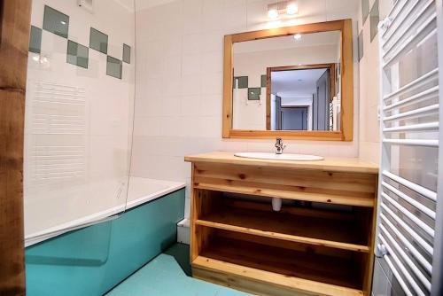 ein Badezimmer mit Waschbecken, Spiegel und Badewanne in der Unterkunft Résidence Les Cristaux - Appartement confortable et rénové · Proche des pistes · Balcon · Sauna · Hammam · WIFI MAE-0674 in Levassaix