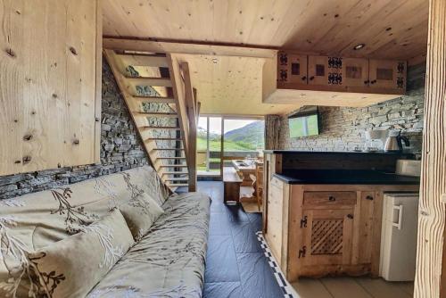 - un salon avec un canapé dans une petite maison dans l'établissement Résidence Caron - Appartement duplex rénové · Départ ski aux pieds · Balcon MAE-0694, aux Menuires