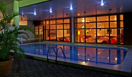 a swimming pool in front of a house at night at The Golden Truly Hotel & Casino in Paramaribo