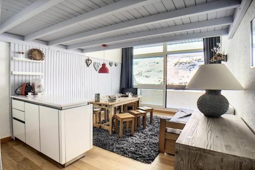 une cuisine et une salle à manger avec une table et une salle à manger dans l'établissement Résidence Danchet - Appartement duplex moderne · Ski aux pieds · Balcon MAE-0714, aux Menuires