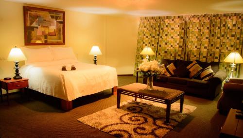 a hotel room with a bed and a couch at The Golden Truly Hotel & Casino in Paramaribo