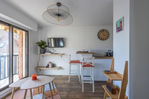 - un salon avec une table et une horloge murale dans l'établissement Le 406, T2 avec balcon & parking à 70m de la mer, à Villers-sur-Mer