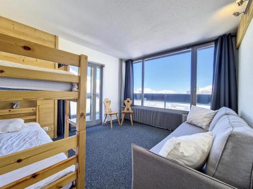 une chambre avec un lit superposé et une grande fenêtre dans l'établissement Résidence Dorons - Appartement rénové · Centre station · Balcon MAE-0734, aux Menuires