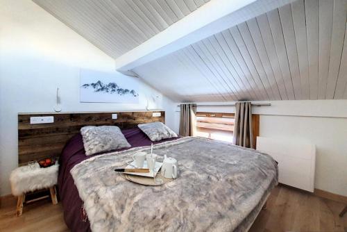 a bedroom with a large bed with a table on it at Résidence Hors Piste - Appartement rénové en duplex · Au pied des pistes · Balcon MAE-0494 in Saint-Martin-de-Belleville