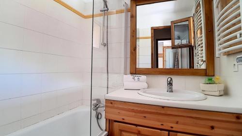 ein Badezimmer mit Waschbecken, Dusche und Spiegel in der Unterkunft Résidence Les Cristaux - Appartement spacieux · Proche des pistes · Balcon · Sauna · Hammam · WIFI MAE-0604 in Levassaix