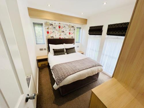 a bedroom with a large bed and windows at 3 Bedroom Lodge SG2, Lower Hyde, Isle of Wight in Shanklin