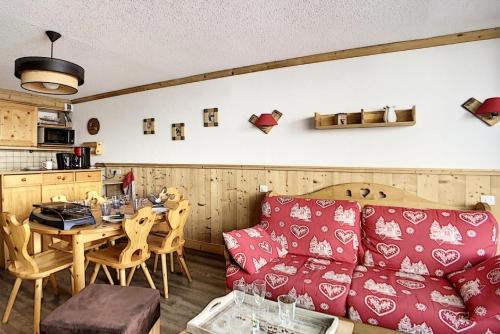 un salon avec un canapé rouge et une table dans l'établissement Résidence Grande Masse - Appartement entièrement rénové · Départ et retour skis aux pieds · Balcon MAE-0634, aux Menuires