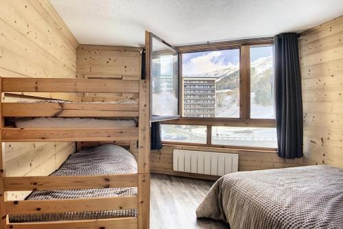 une chambre avec deux lits superposés et une fenêtre dans l'établissement Résidence Grande Masse - Appartement entièrement rénové · Départ et retour skis aux pieds · Balcon MAE-0634, aux Menuires