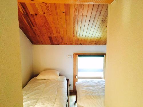 a room with two beds and a wooden ceiling at Résidence Hors Piste - Appartement spacieux en duplex · Au pied des pistes · Balcon MAE-0754 in Saint-Martin-de-Belleville