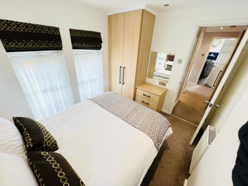 a bedroom with a white bed and a mirror at 3 Bedroom Lodge SG2, Lower Hyde, Isle of Wight in Shanklin