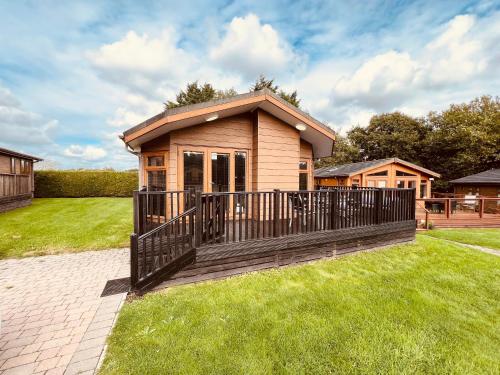 a small house with a deck on the grass at 3 Bedroom Lodge SG2, Lower Hyde, Isle of Wight in Shanklin