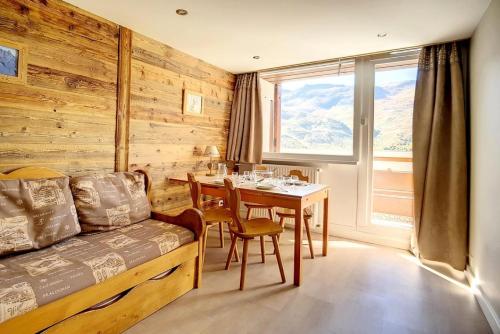 - une chambre avec une table et un lit ainsi qu'une salle à manger dans l'établissement Résidence Les Lauzes - Appartement duplex confortable · Au pied des pistes · Balcon MAE-0944, aux Menuires