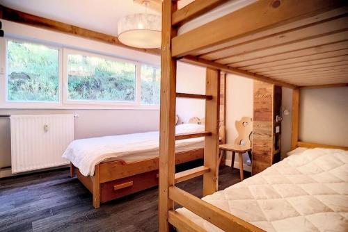 - une chambre avec 2 lits superposés et 2 fenêtres dans l'établissement Résidence Les Lauzes - Appartement duplex confortable · Au pied des pistes · Balcon MAE-0944, aux Menuires