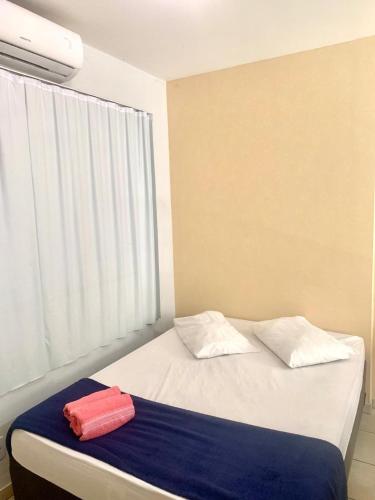 a bed with two red towels on top of it at #Flats Studio 45 Bueno Oeste in Goiânia