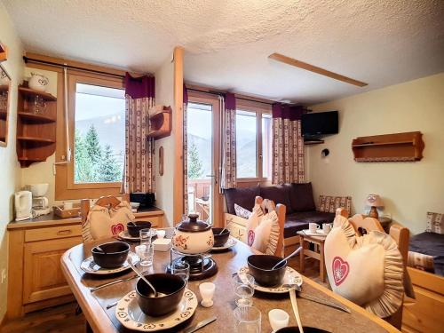 Il comprend un salon avec une table en bois et une cuisine. dans l'établissement Résidence Boedette A - Appartement confortable · Départ et retour skis aux pieds · Balcon MAE-1004, aux Menuires