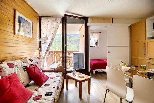 un salon avec un canapé et une table dans l'établissement Résidence Ski Soleil - Appartement lumineux · Départ ski aux pieds · Terrasse MAE-1054, aux Menuires